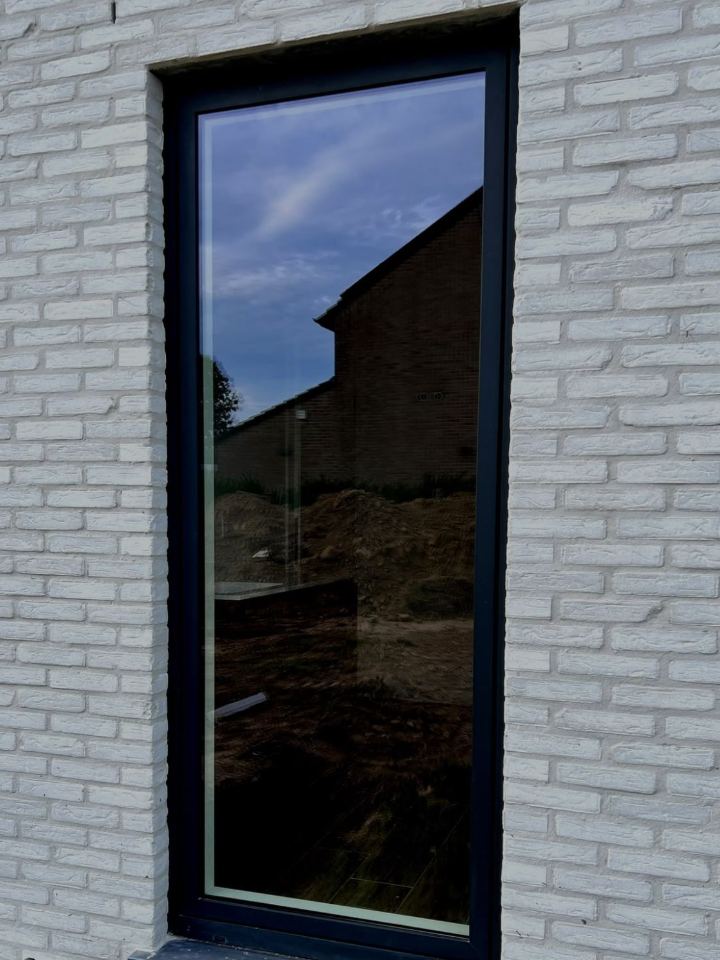 Après : châssis neuf et vitrage impeccables sur façade en briques blanches